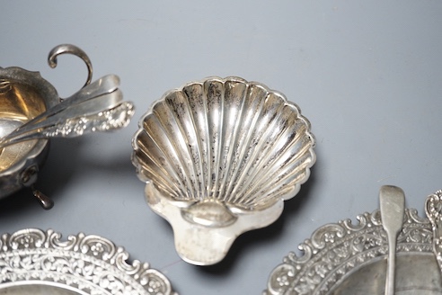 A late Victorian silver butter shell, a later silver sauceboat, seven assorted silver teaspoons including Scottish and two continental white metal dishes(a.f.), gross 16.5oz.